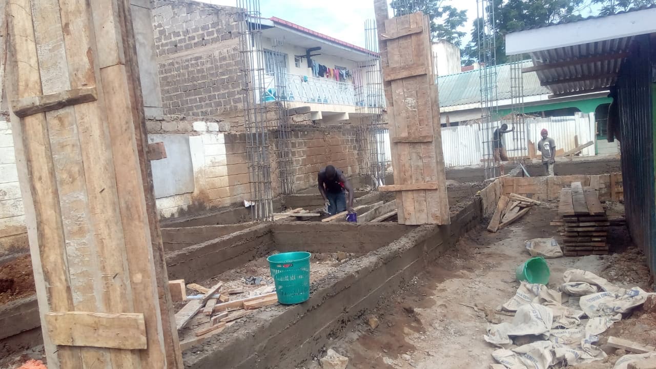 Ground-level view of early blockwork and structural elements at the private hostel development.
